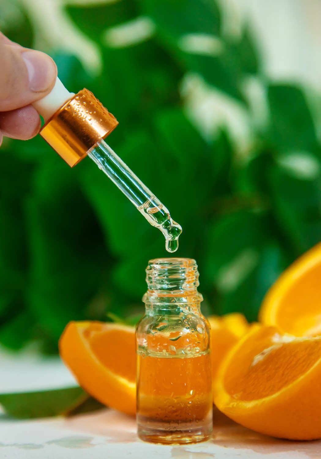Orange essential oil in a small bottle. Selective focus. Nature.